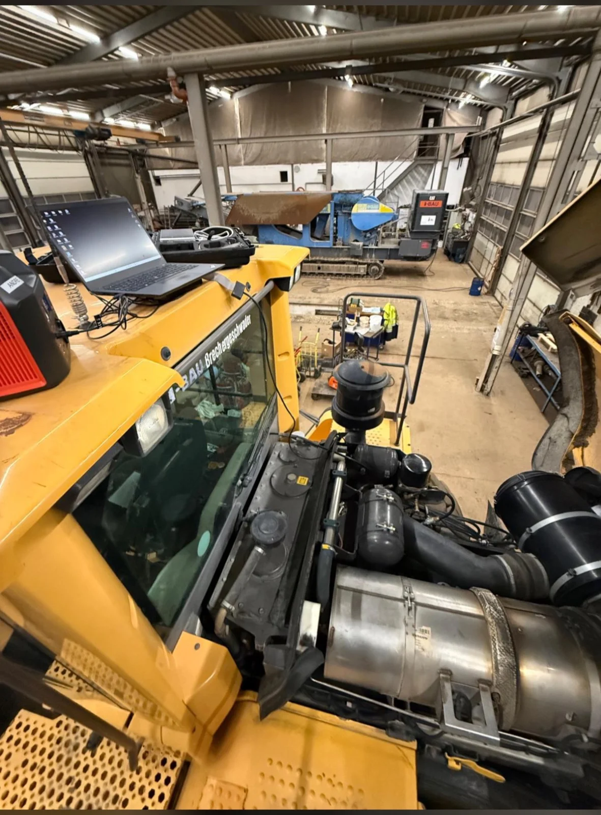 Mobile Brechanlage mit offener Motorhaube und Laptop bei der Kennfeldoptimierung
