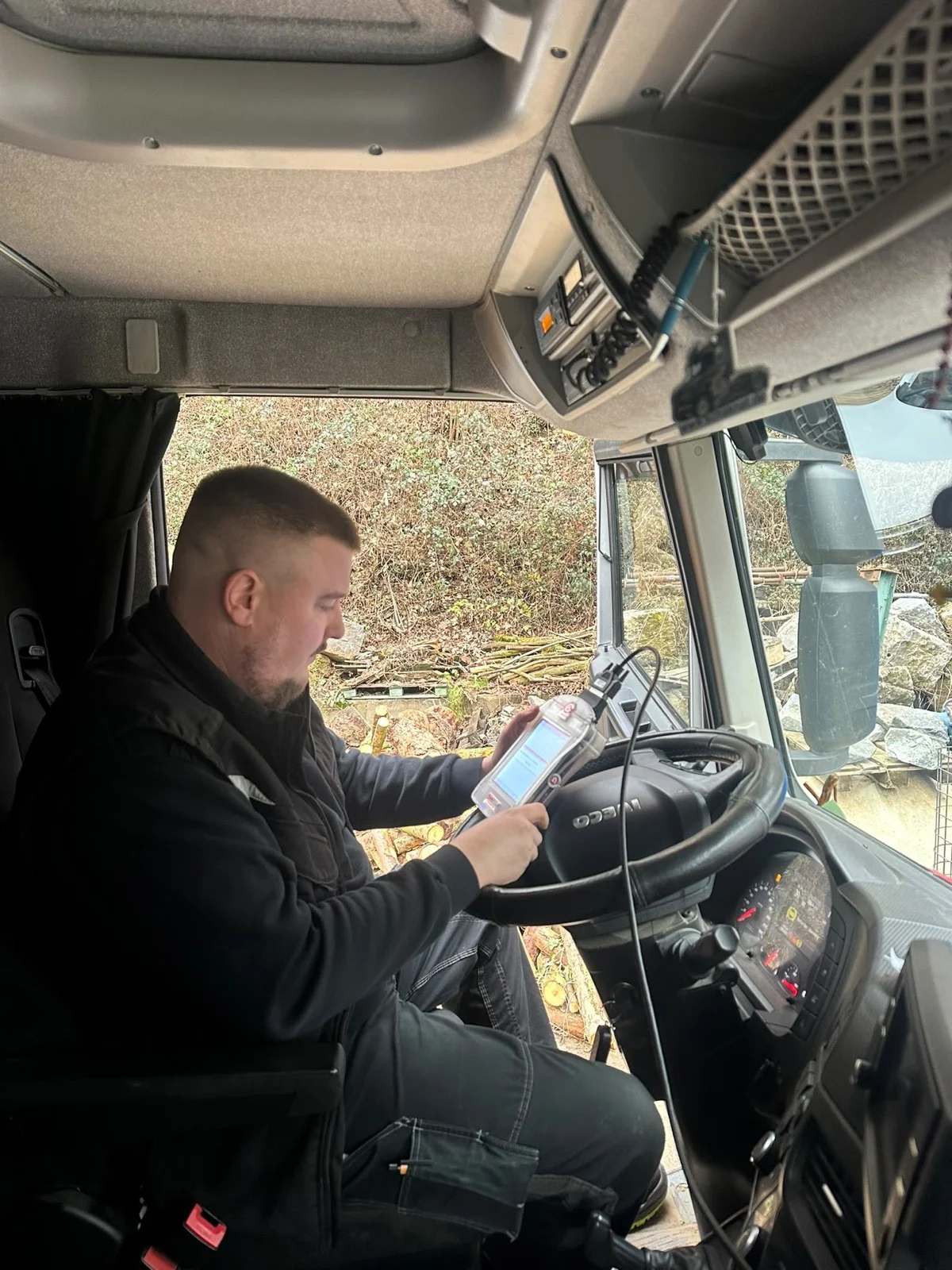 Techniker programmiert das Steuergerät in der Fahrerkabine eines LKW beim Kunden