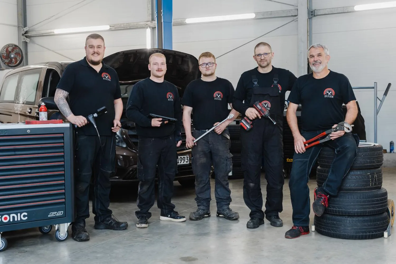 Das Euler-Team mit Werkzeug vor der Werkstatt