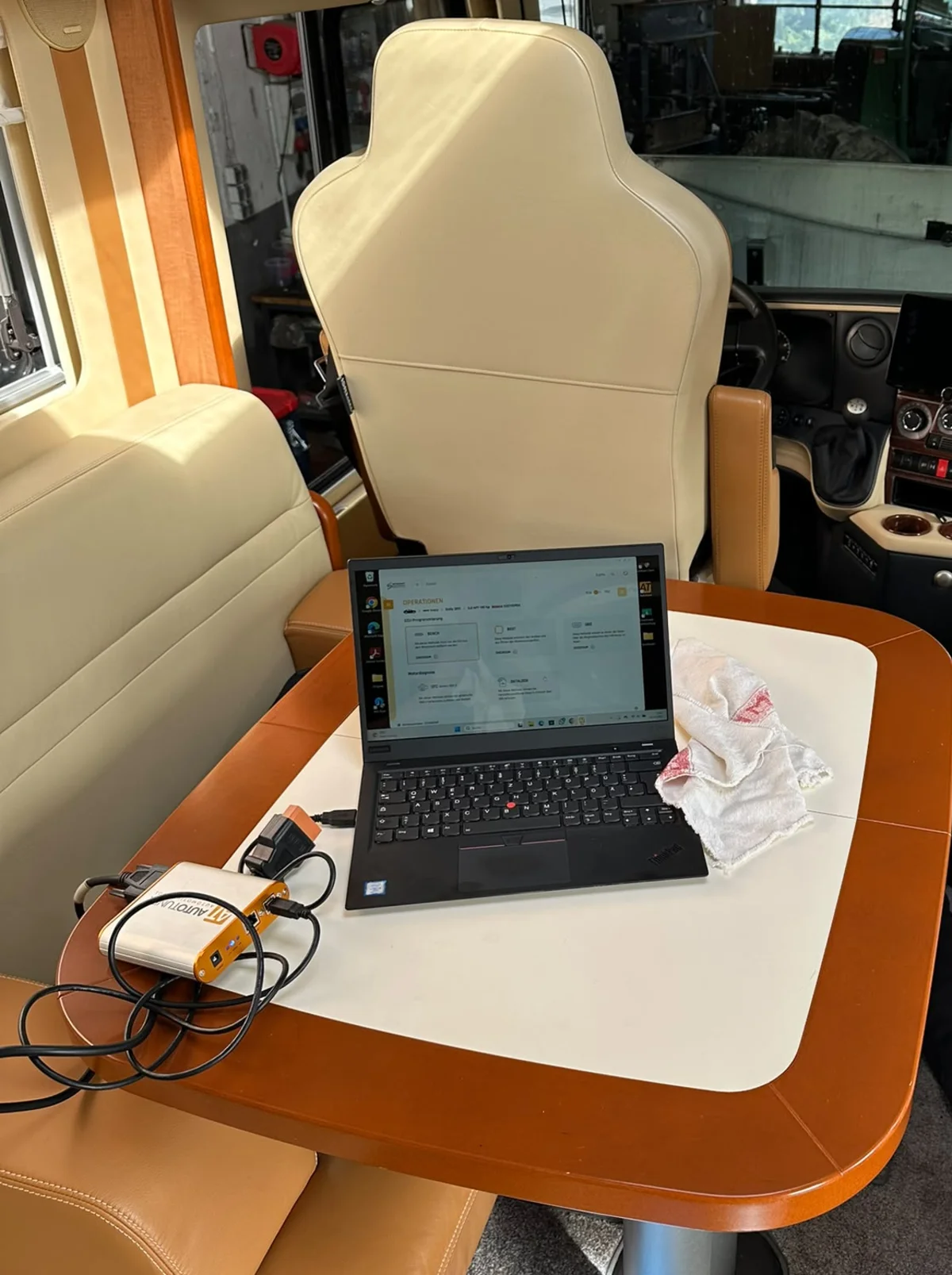 Laptop mit Programmiersoftware und Interface auf dem Tisch im Wohnmobil-Innenraum